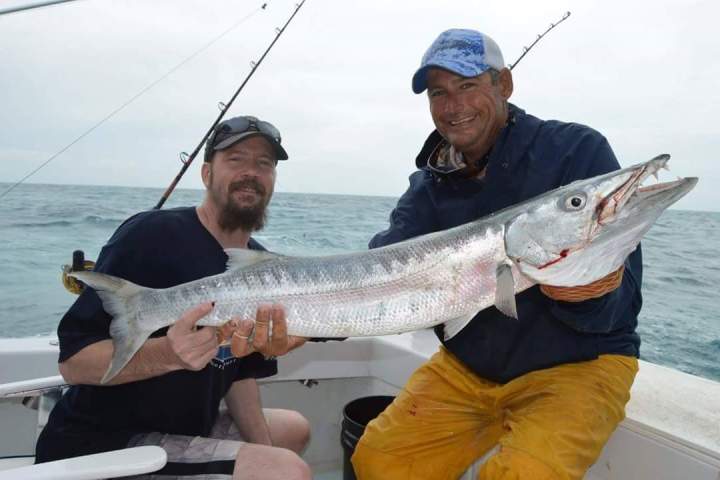 a person holding a fish on a boat