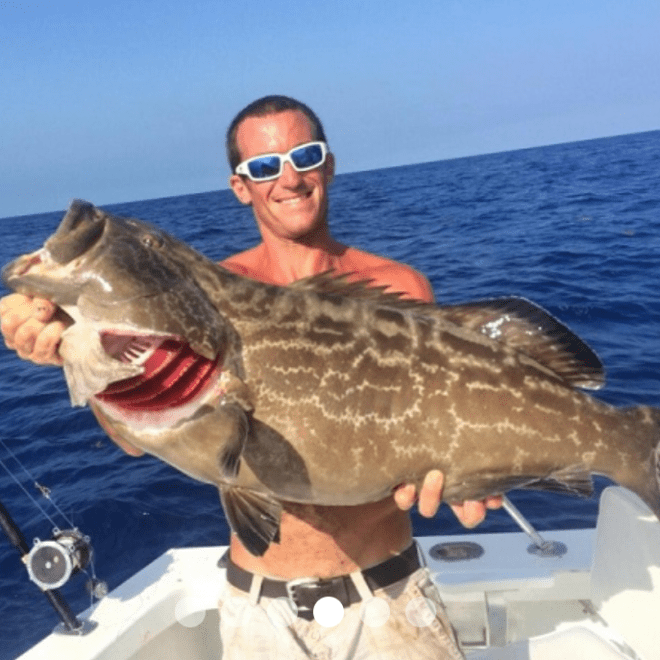 a man holding a fish in the water