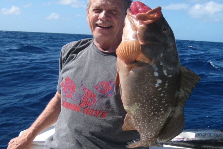 a man holding a fish in the water